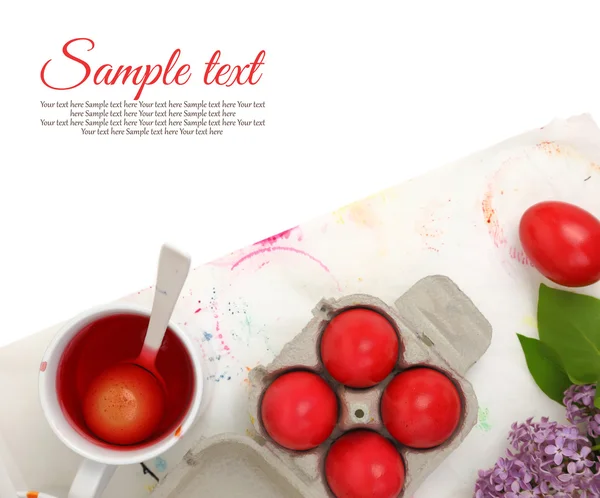Ovos de Páscoa vermelhos e tinta líquida sobre fundo branco — Fotografia de Stock
