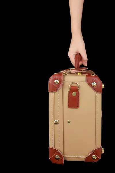 Hand som håller resor resväska isolerade på svart — Stockfoto