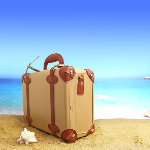 Closed suitcase on tropical beach background Royalty Free Stock Photos