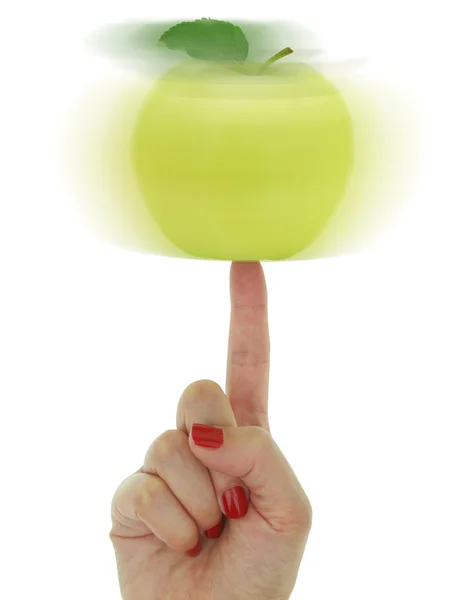 Zöld alma egyensúlyozó egy ujjal női kéz — Stock Fotó