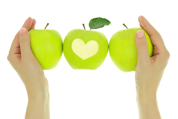 Hands with a row of green apples and heart — Stock Photo, Image