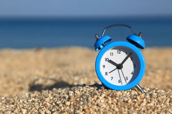Время отпуска. Будильник на пляже — стоковое фото