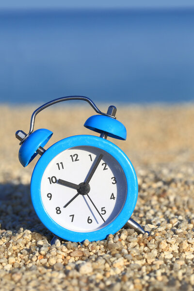Vacation time. Alarm clock on the beach