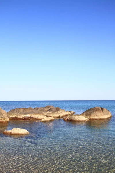 Paisaje marino con rocas costeras, aguas claras y cielo azul — Foto de Stock