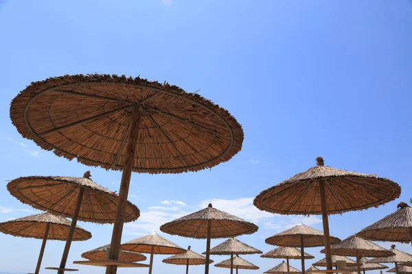 Ombrelli da spiaggia in vimini con cielo blu — Foto Stock