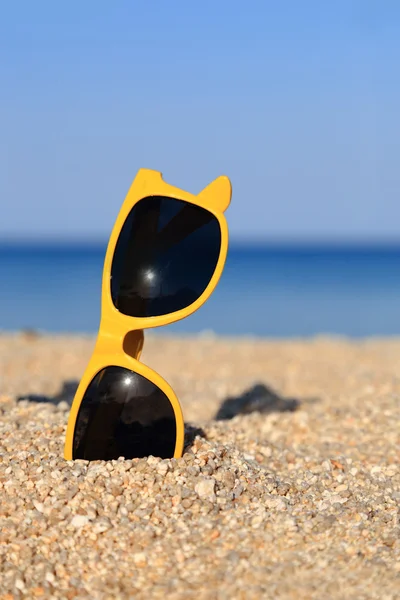 Een paar zonnebril op het strand — Stockfoto