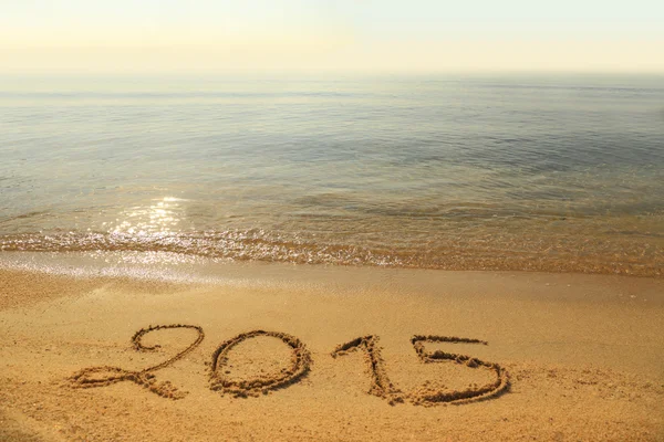 Year 2015 number written on sandy beach — Stock Photo, Image