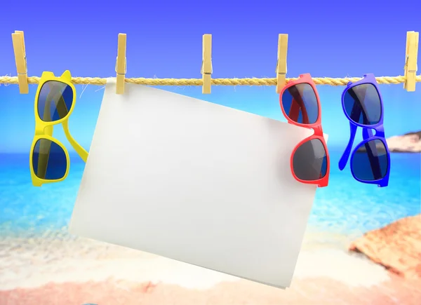 Sonnenbrille und Banner hängen am Seil vor dem Meer — Stockfoto