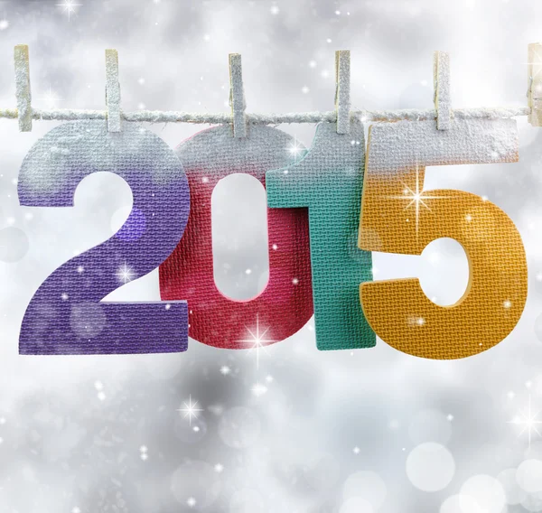 Number 2015 hanging on a clothesline in a glittery lights background — Stock Photo, Image