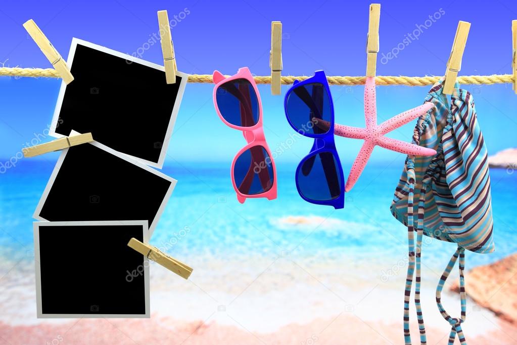 Photo frames and beach items hanging on a rope in front of the sea