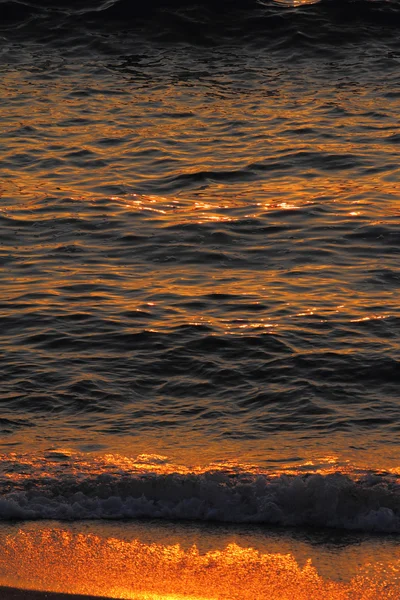 Onde dorate del mare e sabbia al tramonto, primo piano — Foto Stock