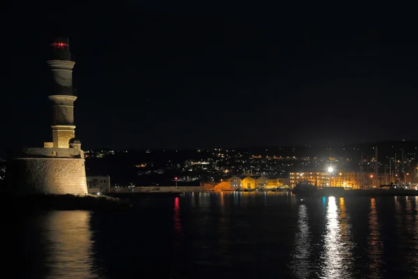 Lighthouse, port and the city of Chania with lights at night