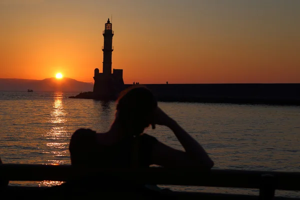 Deniz feneri Hanya Girit arkasında gün batımını izlemek kadın — Stok fotoğraf