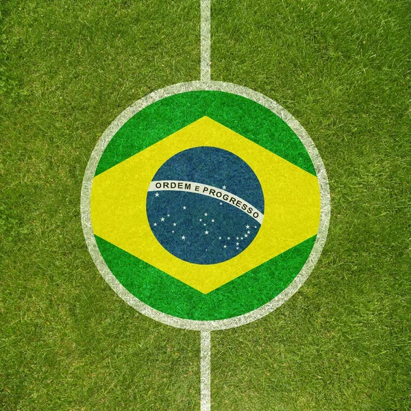 Campo de fútbol centro primer plano con bandera brasileña en círculo — Foto de Stock