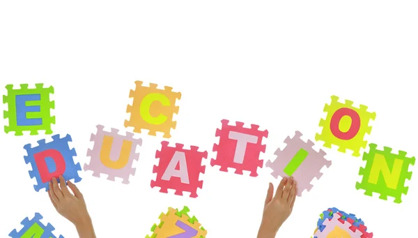 Hands forming word "Education" with jigsaw puzzle pieces isolated — Stock Photo, Image