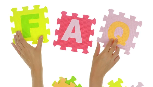 Hands forming word "Faq" with jigsaw puzzle pieces isolated — Stock Photo, Image