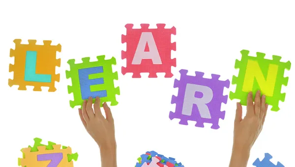 Hands forming word "Learn" with jigsaw puzzle pieces isolated — Stock Photo, Image
