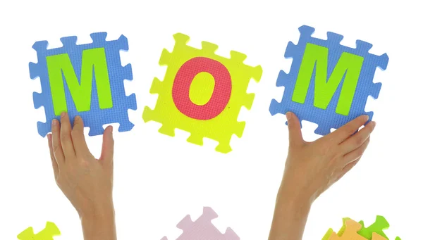 Hands forming word "Mom" with jigsaw puzzle pieces isolated — Stock Photo, Image