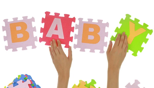 Hands forming word "Baby" with jigsaw puzzle pieces isolated — Stock Photo, Image