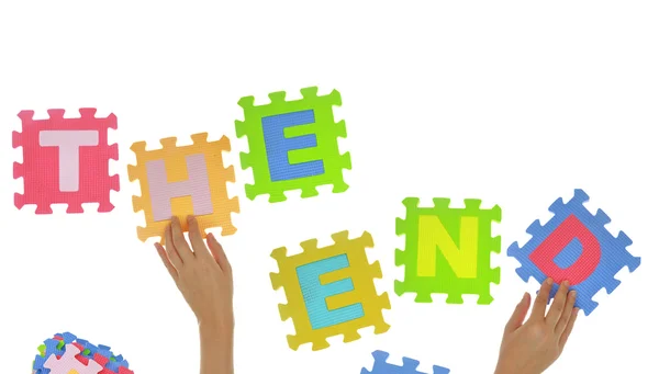 Hands forming words "The end" with jigsaw puzzle pieces — Stock Photo, Image