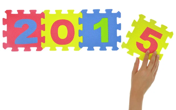 Mano formando "2015" con pezzi puzzle isolati — Foto Stock