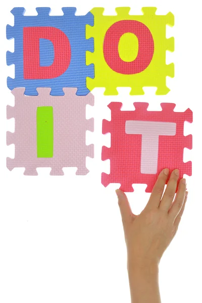 Hand forming phrase "Do it" made with jigsaw puzzle pieces — Stock Photo, Image