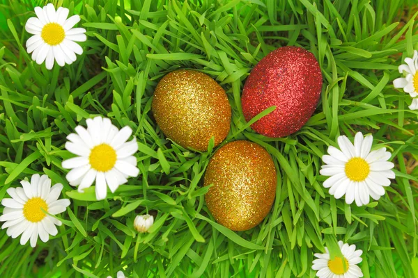 Pasen achtergrond met gras, bloemen en kleurrijke glitter eieren — Stockfoto