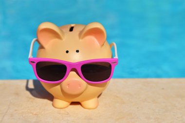 Summer piggy bank with sunglasses in front of a swimming pool clipart