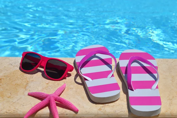 Chanclas, gafas y estrellas de mar junto a la piscina —  Fotos de Stock