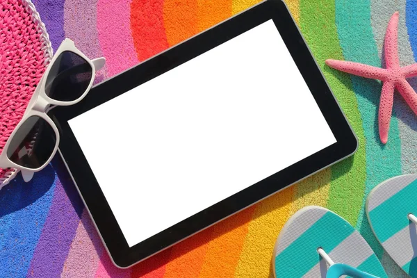 Tablet met leeg scherm op strandlaken met accessoires — Stockfoto