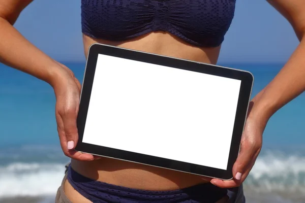 Женщина держит планшетный компьютер на пляже — стоковое фото