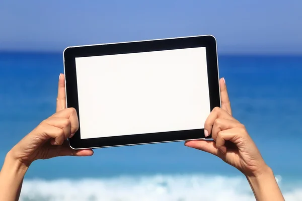 Woman hand holding tablet computer on the beach — Stock Photo, Image