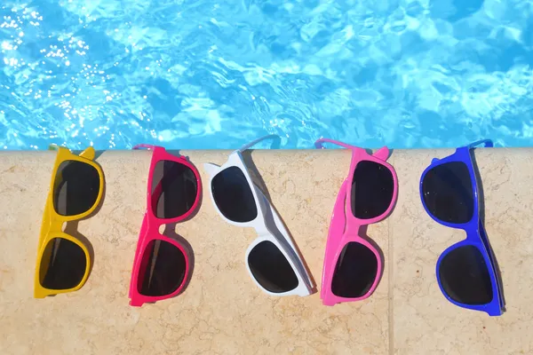 Gafas de sol coloridas en la fila junto a la piscina — Foto de Stock