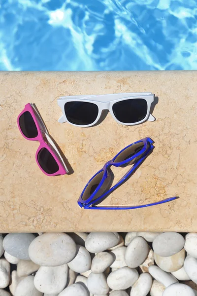 A medence mellett színes napszemüveg — Stock Fotó