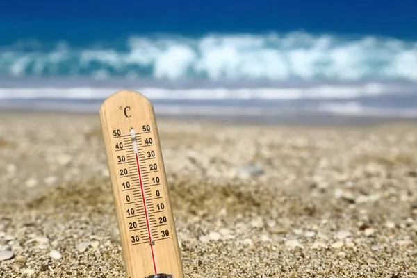 Termômetro em uma praia mostra altas temperaturas — Fotografia de Stock