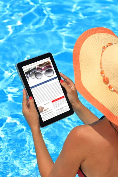 Mujer sosteniendo la tableta en la piscina — Foto de Stock