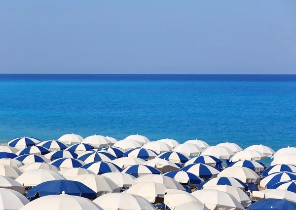 Topy z bílé a modré slunečníky kathisma Lefkáda Řecko — Stock fotografie