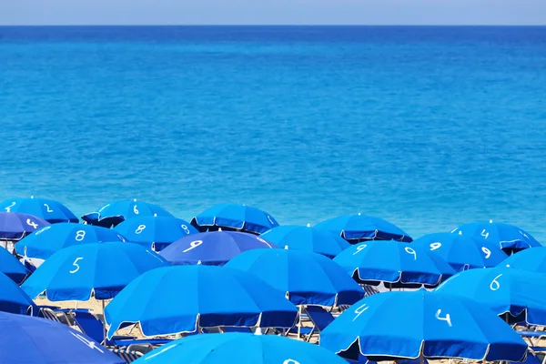 Mavi plaj şemsiyeleri ve deniz kathisma lefkada Yunanistan üst kısımları — Stok fotoğraf