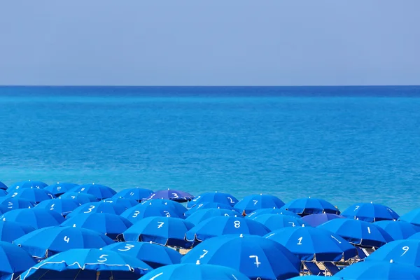 Spitzen von blauen Sonnenschirmen und Meer kathisma lefkada Griechenland — Stockfoto
