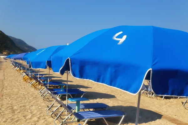 Playa de arena con sombrillas azules y tumbonas Kathisma Lefkada —  Fotos de Stock