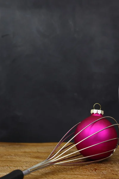 Christmas ball in cooking beater and copy space on black background — Stock Photo, Image