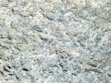 Gri bej rengi duvar arkaplan dokusu. Delikli kayalık formasyon, sert malzeme. Soyut doğal sert yüzey. Yunan adası Kiklad Yunanistan.