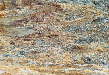 Gri kahverengi taş duvar arka plan dokusu. Rocky delikleri ve pürüzlü malzemelerle çatladı. Soyut doğal sert yüzey. Yunan adası Kiklad Yunanistan.