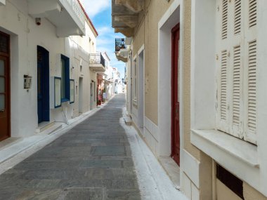 Andros Adası 'nın varış noktası Cyclades Yunanistan. Whitewashed duvarlar arasında Chora kasabasında dolaşırken hediyelik eşya dükkanları asfaltlı sokak. Tatil beldesi