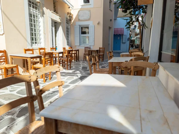 ギリシャの屋外伝統的な居酒屋レストランティノス島 コラ町 キクラデスギリシャ 石畳の通りに大理石のテーブルとわらの椅子 — ストック写真