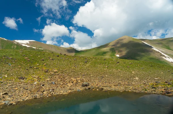 Petites montagnes avec lac coloré et ciel bleu foncé et nuages — Photo