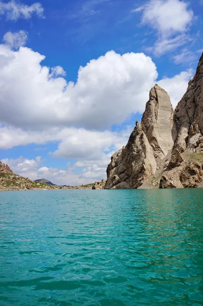 Grandiosas rocas y el lago de montaña Kelsu sobre el fondo del colorido cielo azul oscuro con nubes —  Fotos de Stock