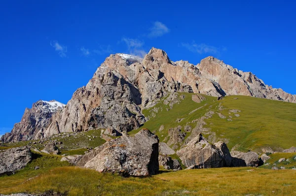 Malá hora na pozadí úžasný modrou oblohu s mraky — Stock fotografie