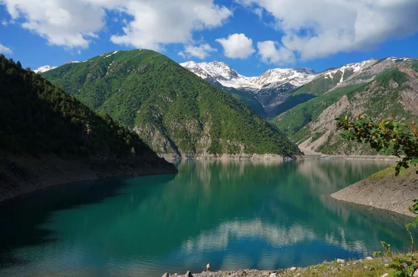 Encantador lago entre altas montañas pintorescas y una nube en el cielo azul —  Fotos de Stock