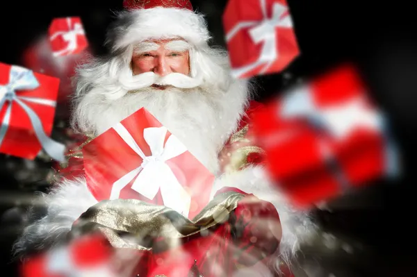 Santa Claus holding his bag and smiling. Gift boxes are flying f — Stock Photo, Image